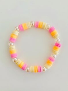 a bracelet made out of multicolored plastic beads and pearls on a white background