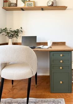 a desk with a laptop on top of it and a chair in front of it