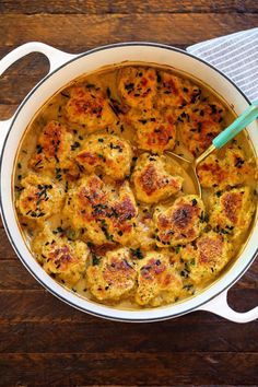 a casserole dish with meatballs in it and a spoon on the side