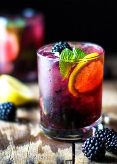 a glass filled with fruit and ice on top of a wooden table