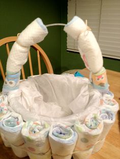 several rolls of diapers sitting on top of a wooden table next to a chair