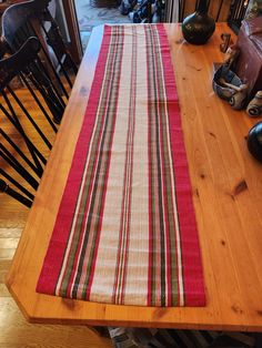 a wooden table topped with a red and white striped runner