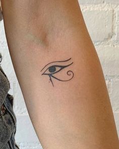 a woman's arm with an eye tattoo on the left side of her arm