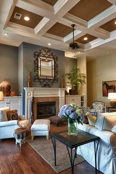 a living room filled with furniture and a fire place under a mirror on the wall