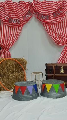 there are two hats on the table with other items in front of them, including a suitcase and some straw bales