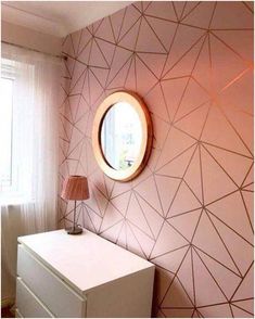 a white dresser sitting next to a window with a round mirror on top of it