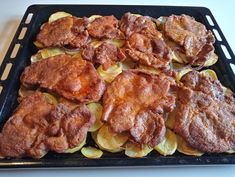 some food is sitting on a black tray and ready to be cooked in the oven