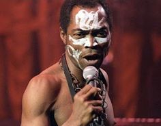 a man with white paint on his face holding a microphone