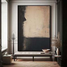 an abstract painting hangs on the wall above a bench in front of a large window