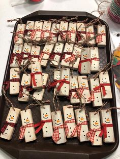 snowmen made out of marshmallows tied with twine on a tray