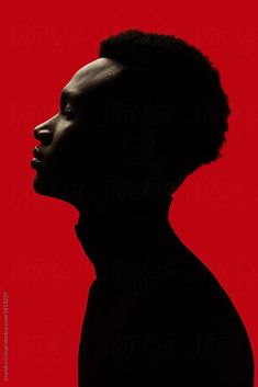 the silhouette of a man's head against a red background