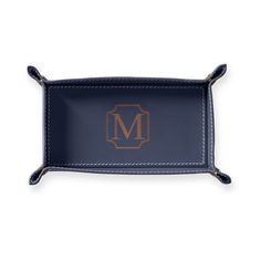 a blue leather tray with the letter m in gold on it and an embroidered monogrammed