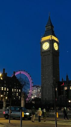 the big ben clock tower towering over the city of london at night with people walking around