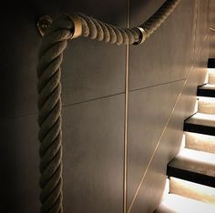 the rope is attached to the wall next to the stairs with lights shining on it