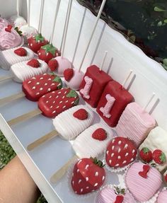 strawberry cupcakes and strawberries are arranged in rows on a white table outdoors