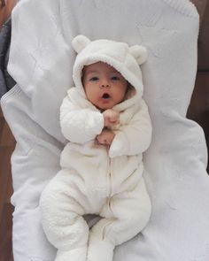 a baby in a white bear costume laying down