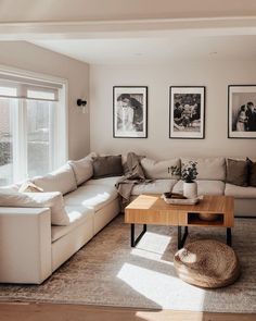 a living room with couches and pictures on the wall above them, along with a coffee table