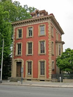 an old red brick building sitting on the corner of a street