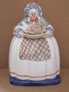 a ceramic clown sitting on top of a pumpkin