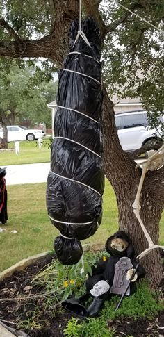 a tree that has been wrapped in black plastic and is sitting on the ground next to a