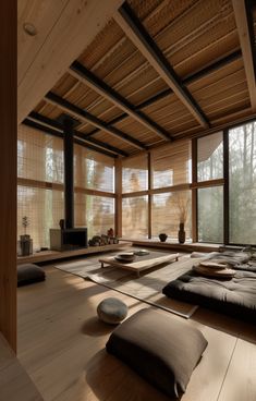 a large room with lots of windows and wooden flooring on one side, two tatami mats on the other