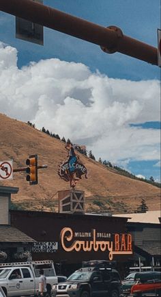 cars are parked in front of a building with a cowboy sign on the side of it