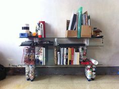 a shelf filled with books and magazines next to a wall