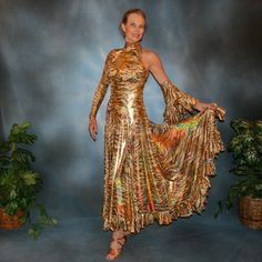 will fit size 5/6-9/10...5'6" or taller Be the envy of the dance floor with this stunning Gold Hologram Tango-Paso Doble Dress! Crafted of golden iridescent hologram tiger print lycra, this elegant ensemble boasts lots of flounces, a long sleeve with a peak at the wrist, and shimmering accents courtesy of volcano colored Swarovski rhinestones, which shine several different shades including purple & yellow. Make a statement with two thigh-high slits in the front, and show off your amazing tango Gold Fitted Disco Dress, Gold Fitted Dance Dress, Gold Fitted Dress For Dance, Spanish Princess, Spanish Dress, Tango Dress, Tiger Print, The Dance, Dance Floor