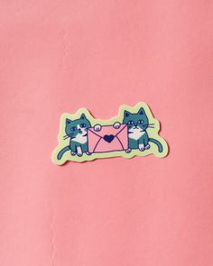 a sticker with two cats sitting on it's back and holding a envelope