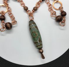 Tibet Agate "heaven's eye" Necklace Bronze and Wood Beads in Copper 40" long Main focal is approximately 2 1/4" long Dzi (pronounced Zee) is a Tibetan word used to describe a patterned, usually agate, of mainly oblong, round, cylindrical or tabular shape pierced lengthwise called Heaven's Bead (tian zhu) in Chinese. This bead has 3 "eyes" - The 3 eyed Dzi bead represents the three stars of luck, happiness, honor, and longevity. It is the bead of wealth and health to bring continuous fortune. Coa Tibetan Jewelry, Three Star, 3rd Eye, Eye Necklace, Tibet, Wood Beads, Agate, Copper, Pendant Necklace