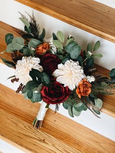 a bouquet of flowers sitting on top of a wooden staircase