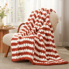 a red and white blanket sitting on top of a chair