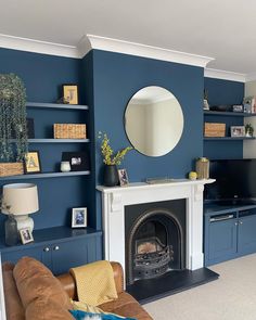 a living room with blue walls and a fire place in the center, surrounded by furniture