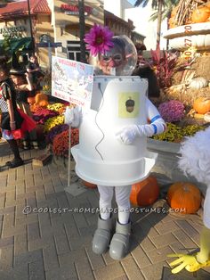 a person in a costume standing next to some pumpkins