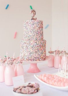 a table topped with a cake covered in sprinkles