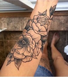 a woman's arm with a flower tattoo on it