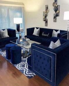 a living room filled with blue velvet couches and matching chairs in front of a window