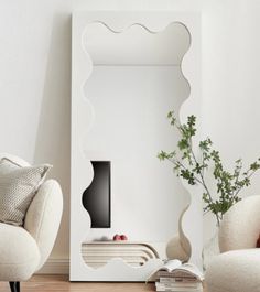 a living room with two chairs and a large mirror