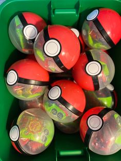 a green container filled with red and black balls