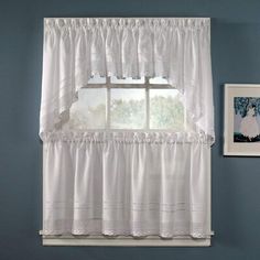 a window with white ruffled curtains in front of it