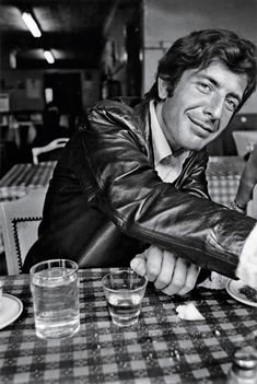 a man sitting at a table with plates and glasses