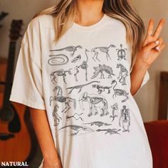 This Zoology Archaeology shirt is super soft and cozy. Perfect to lounge around, run errands, or walk your dog. ABOUT THIS SHIRT   ∙ Shirt is UNISEX and runs slightly large for ladies (For a relaxed fit, I suggest your usual size. For an oversized fit, I suggest sizing up 1 to 2 sizes.) ∙ Solid Colors: 100% airlume ringspun cotton, Dark Grey Heather: 52% cotton, 48% polyester, Athletic Heather 90% cotton, 10% polyester ∙ Colors may vary based on your monitor/screen display or lighting CARE INSTR Casual Dinosaur Print Tops For Fall, Casual Dinosaur Print Tops For Streetwear, Casual Dinosaur Print Relaxed Fit Top, Casual Dinosaur Print Top With Relaxed Fit, Casual Relaxed Fit Top With Dinosaur Print, Casual Relaxed Fit T-shirt With Dinosaur Print, Marine Biology Shirts, Biology Anatomy, Anatomy Bones