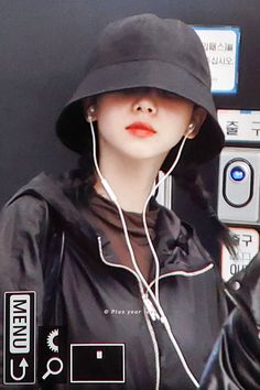 a woman wearing a black hat and ear buds