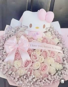 a hello kitty bouquet with pink roses and baby's breath in the center is shown