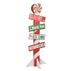 a tall candy cane with street signs on it's top and the words north pole