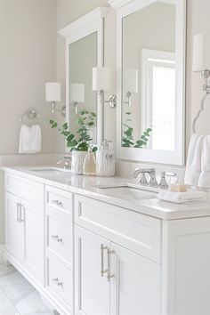 a white bathroom with double sinks and mirrors