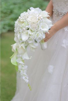 a bride holding a bouquet of white flowers