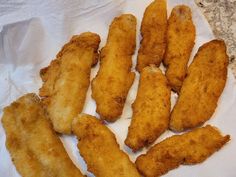 some fried fish sticks are on a paper towel