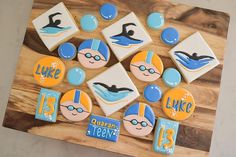 decorated cookies are displayed on a cutting board with numbers and symbols for swimming, diving