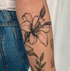 a woman's arm with a flower tattoo on it